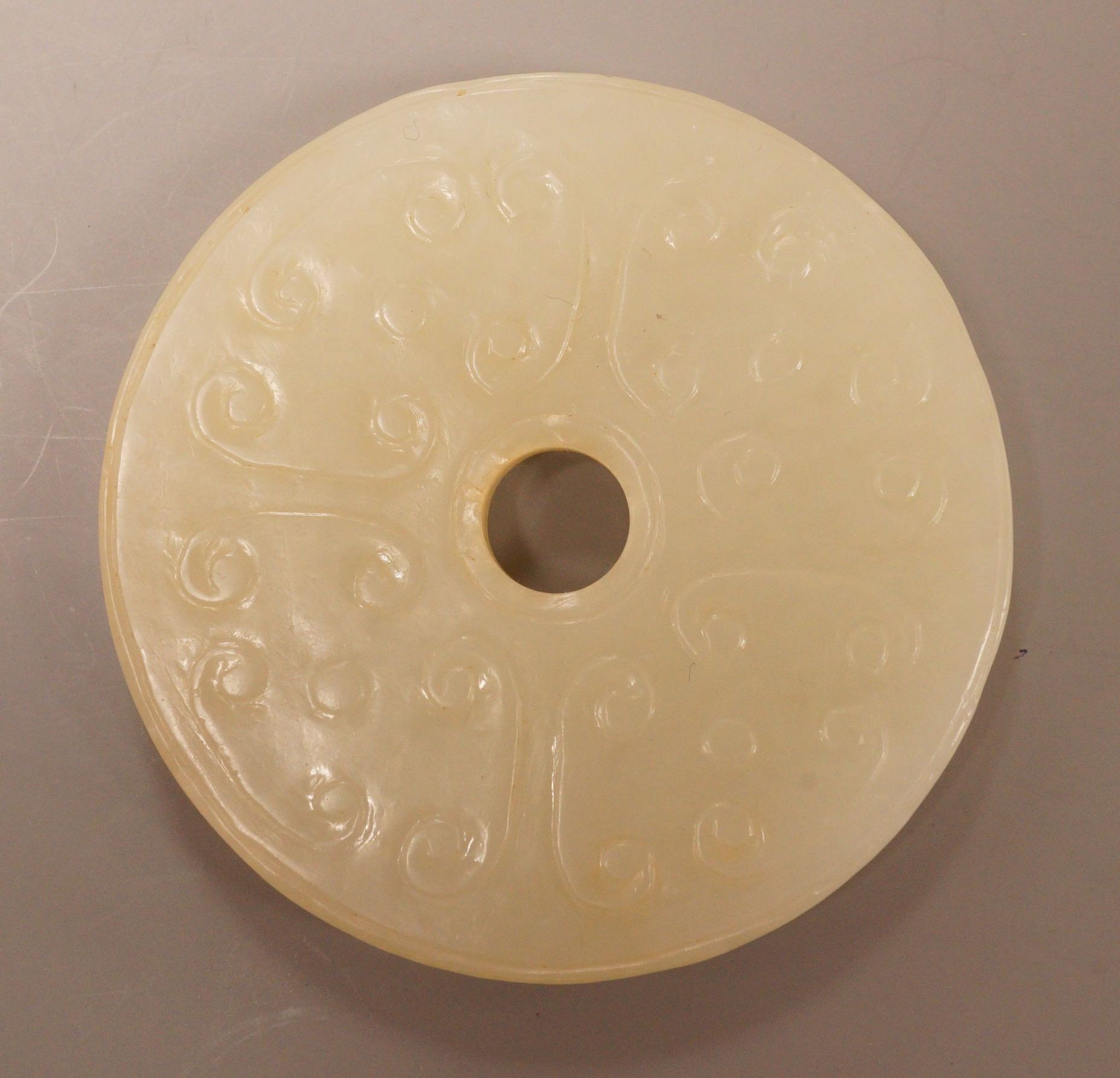 A Chinese pale celadon jade bi disc